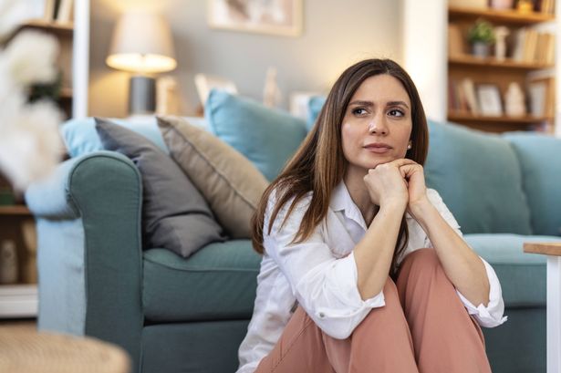 Thinking, sad and woman in home on the floor with anxiety for issue, depression and reflection in living room. 