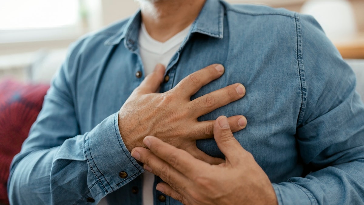 Man holding chest with heart pain