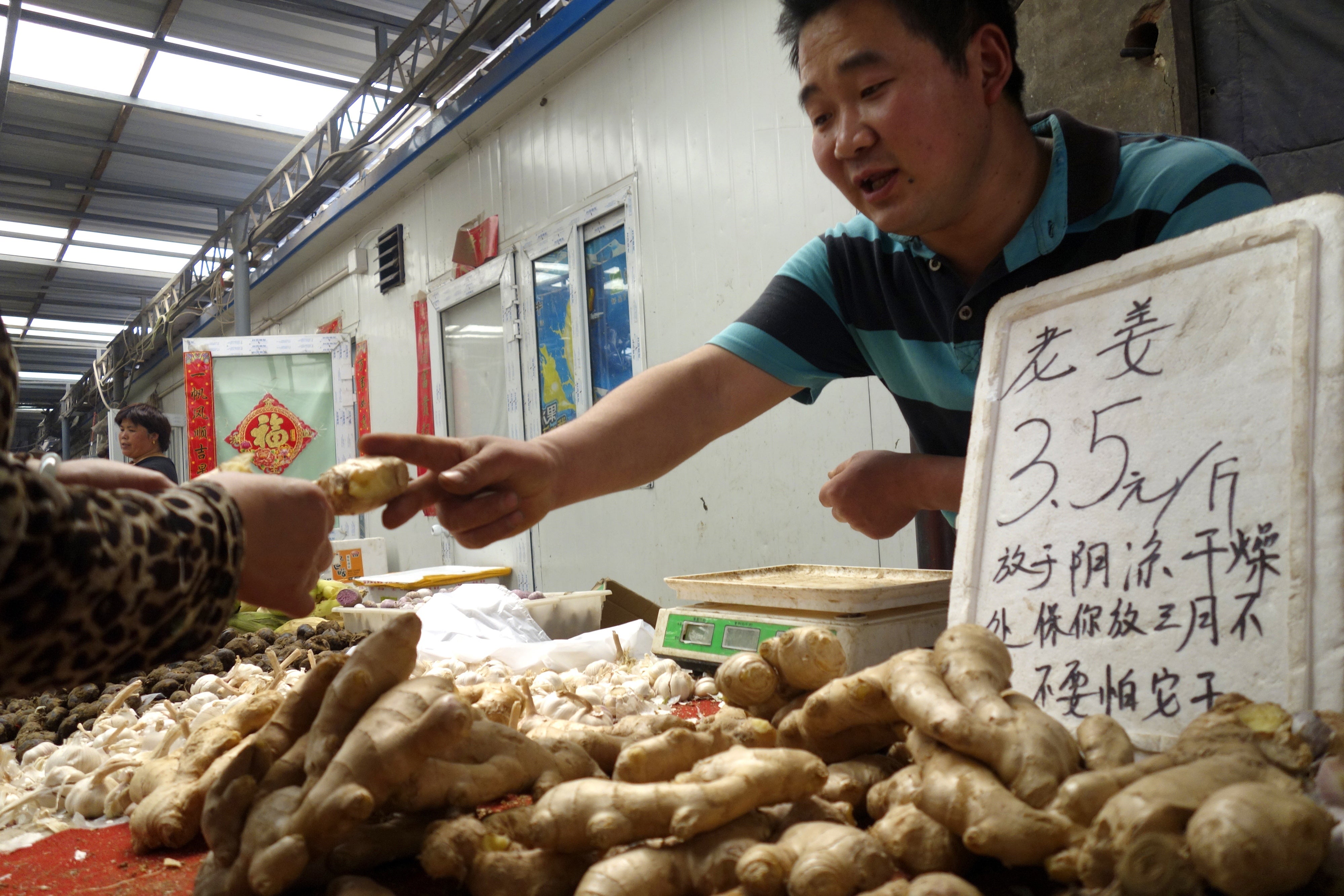 A Chinese vendor sells ginger root at a market in Beijing. Ginger is known to help settle the gut