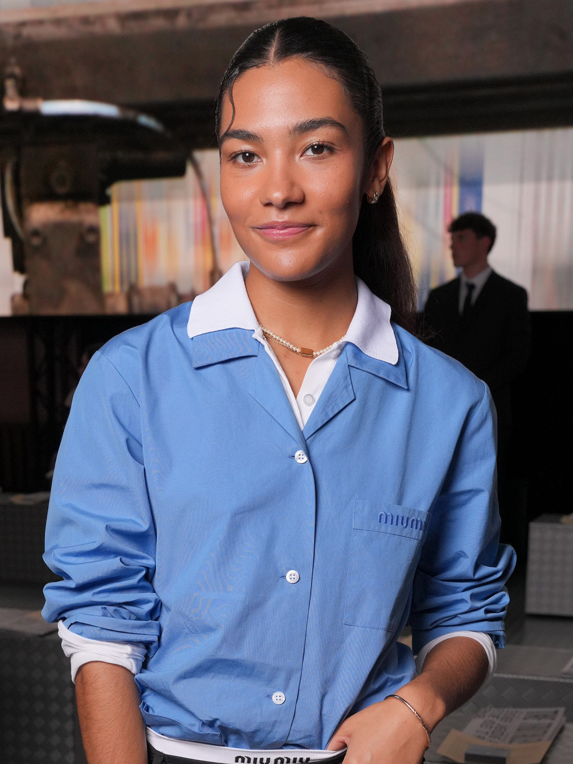 Olivia Dean at the Miu Miu Ready-to-Wear Spring 2025 show during Paris Fashion Week with a dewy complexion and frosted, pink lips