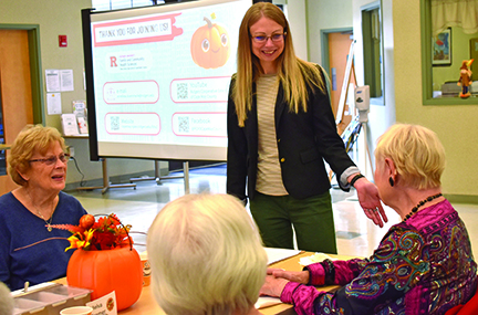 A person delivering a presentation to seniors