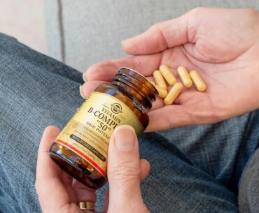 A photo of a man pouring vitamin B supplements into his hand.