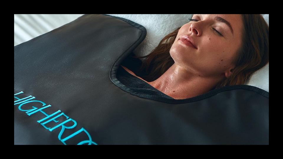 A close-up of a woman in the Higherdose sauna blanket with a black border