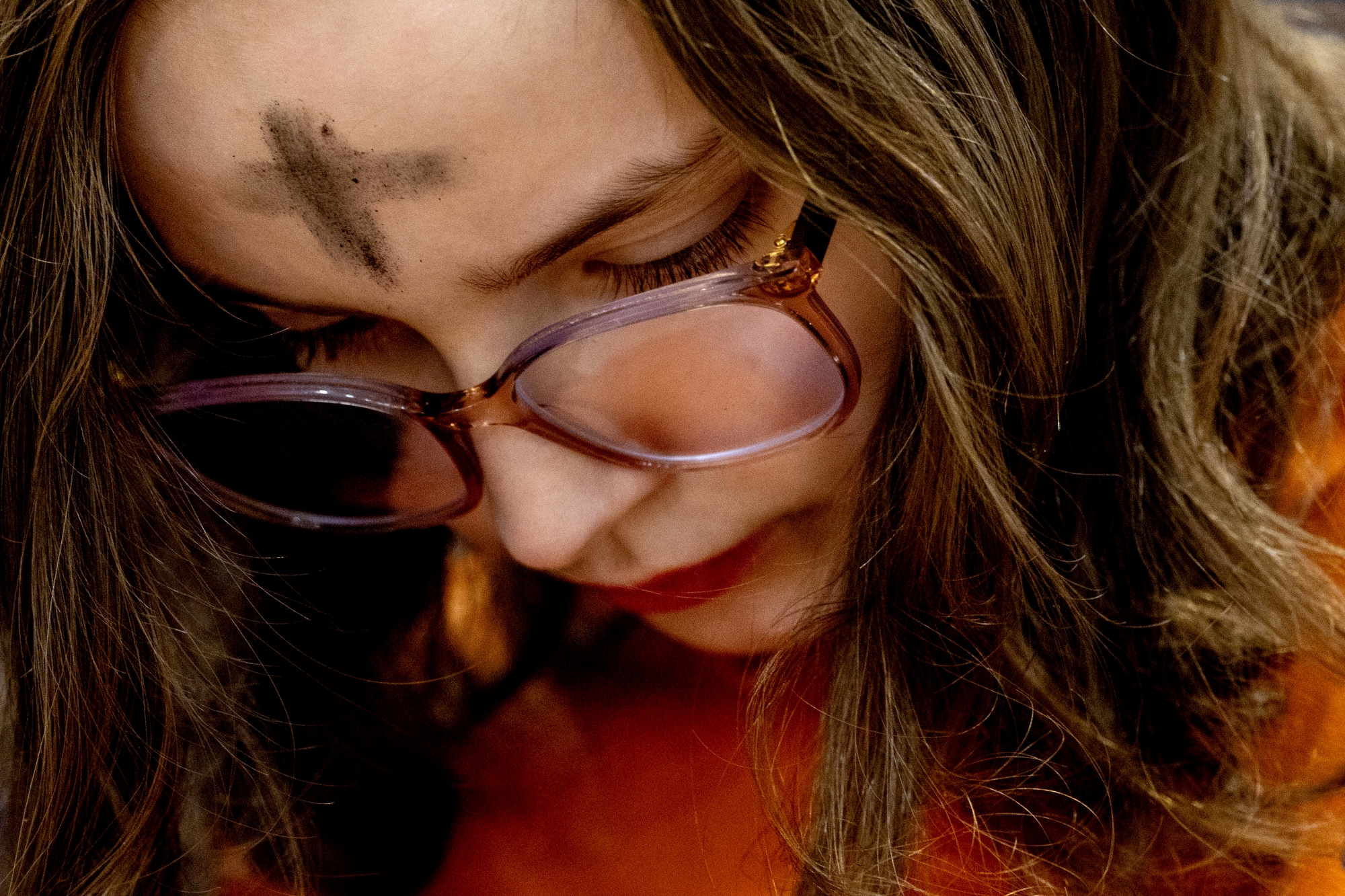 Flint Powers Catholic sophomore Mary Coyne, 14, prays after receiving the ash cross on her forehead alongside more than 550 students during an Ash Wednesday service on Wednesday, March 5, 2025 at Flint Powers Catholic High School in Flint.