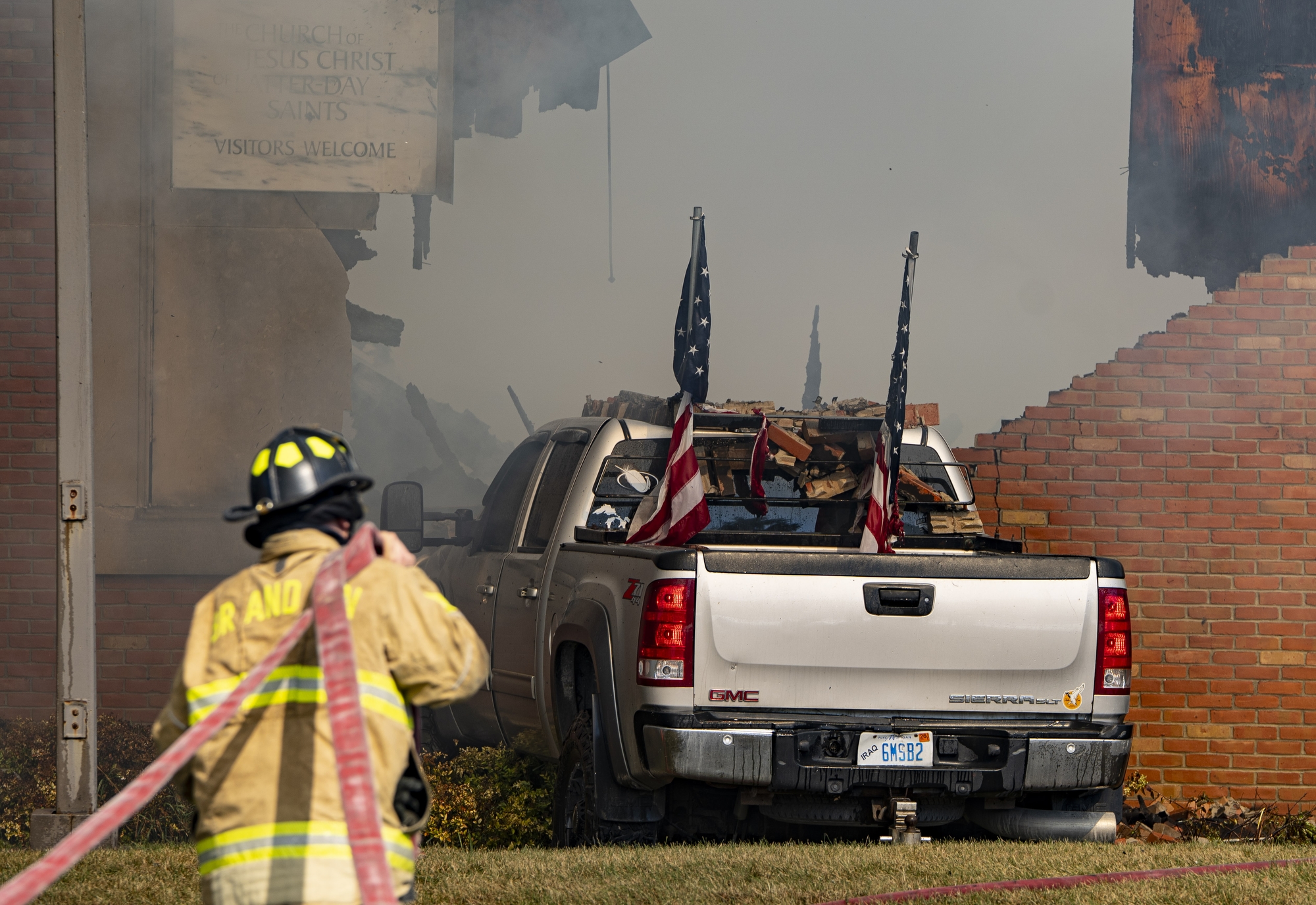 A firefighter works to put out a fire at the Church of Jesus Christ of Latter-day Saints in Grand Blanc Township after a Burton man drove into the building and opened fire on Sunday, Sept. 28, 2025 in Grand Blanc. Police say the fire was set intentionally by the suspect.