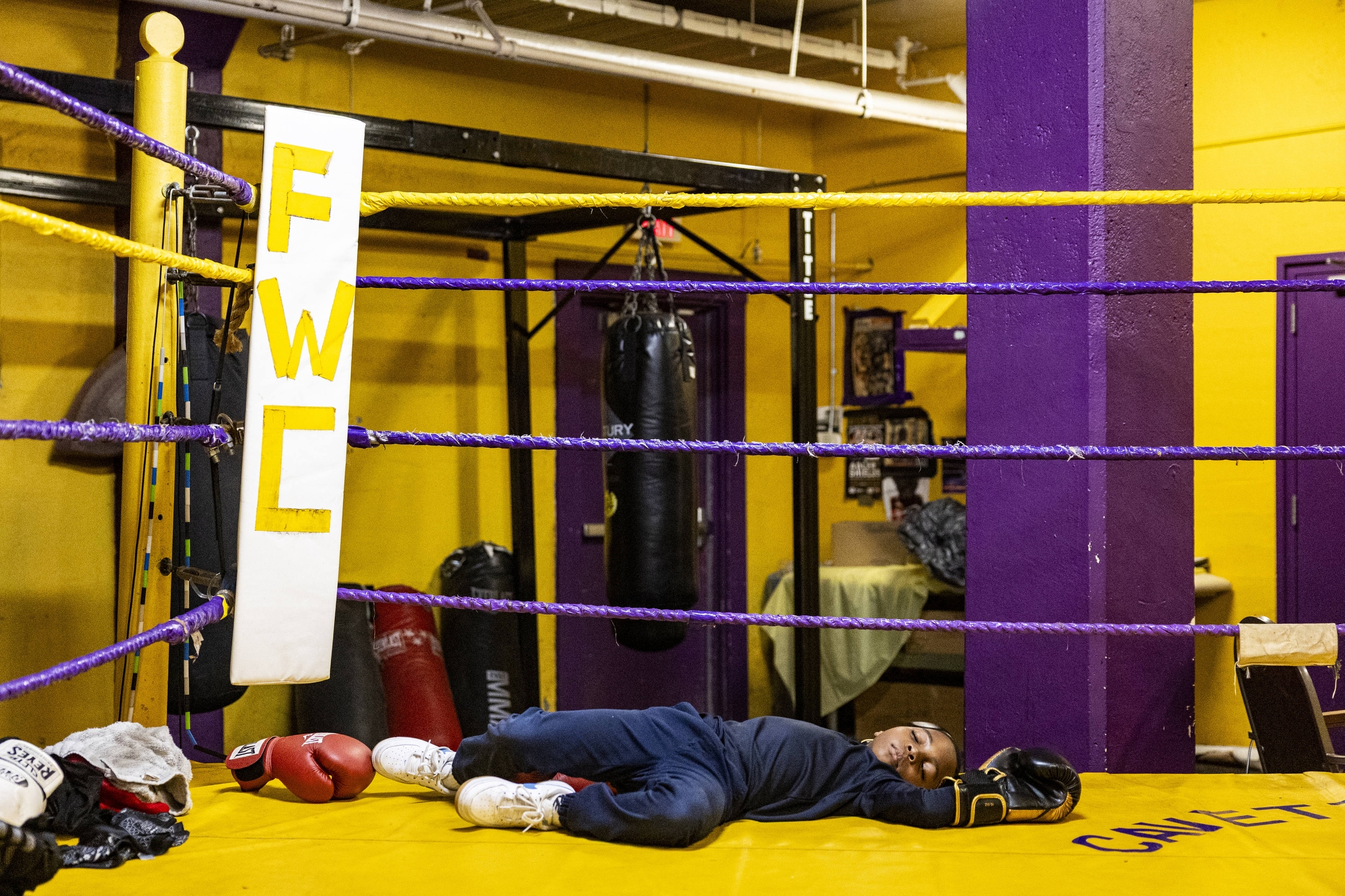 Eli Kendall, son of Coach Bean, sleeps in the ring as Ja’Quan McElroy trains elsewhere in the gym on Thursday, May 29, 2025, at Berston Field House in Flint.