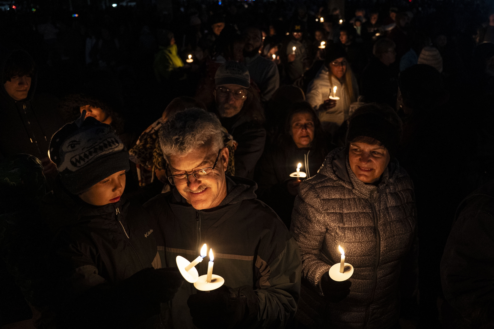 Attendees light candles as they listen to the Saginaw Youth Choir sing Christmas carols at the Saginaw Water Treatment Plant lighting ceremony during Holidays in the Heart of the City festivities in Saginaw on Friday, Nov. 21, 2025.