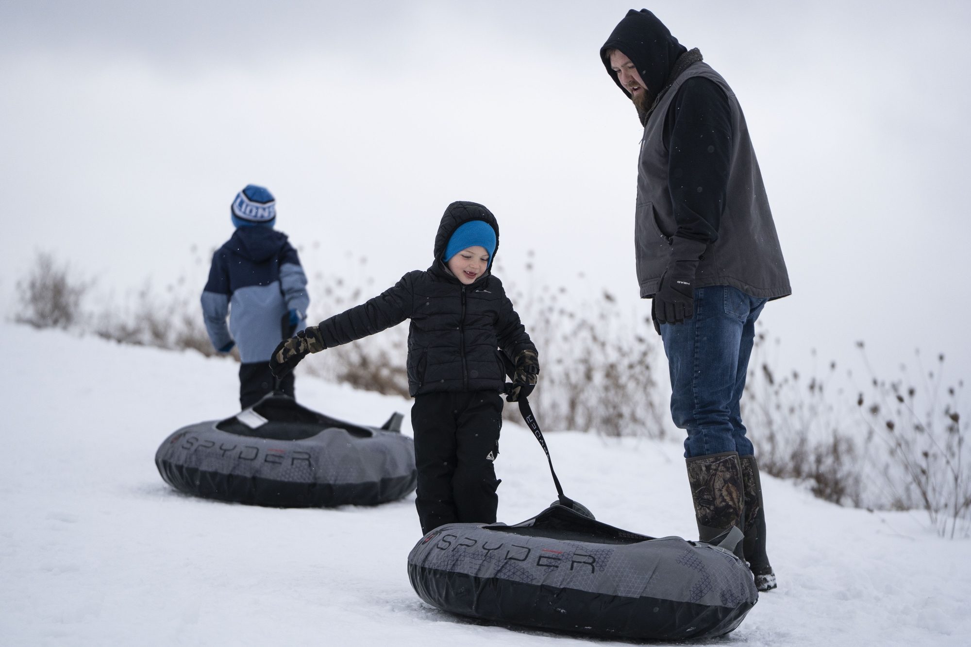 Cody Spalding and his son Cooper Spalding make their way up the hill at Creasey Bicentennial Park in Grand Blanc on Wednesday, Dec. 10, 2025.