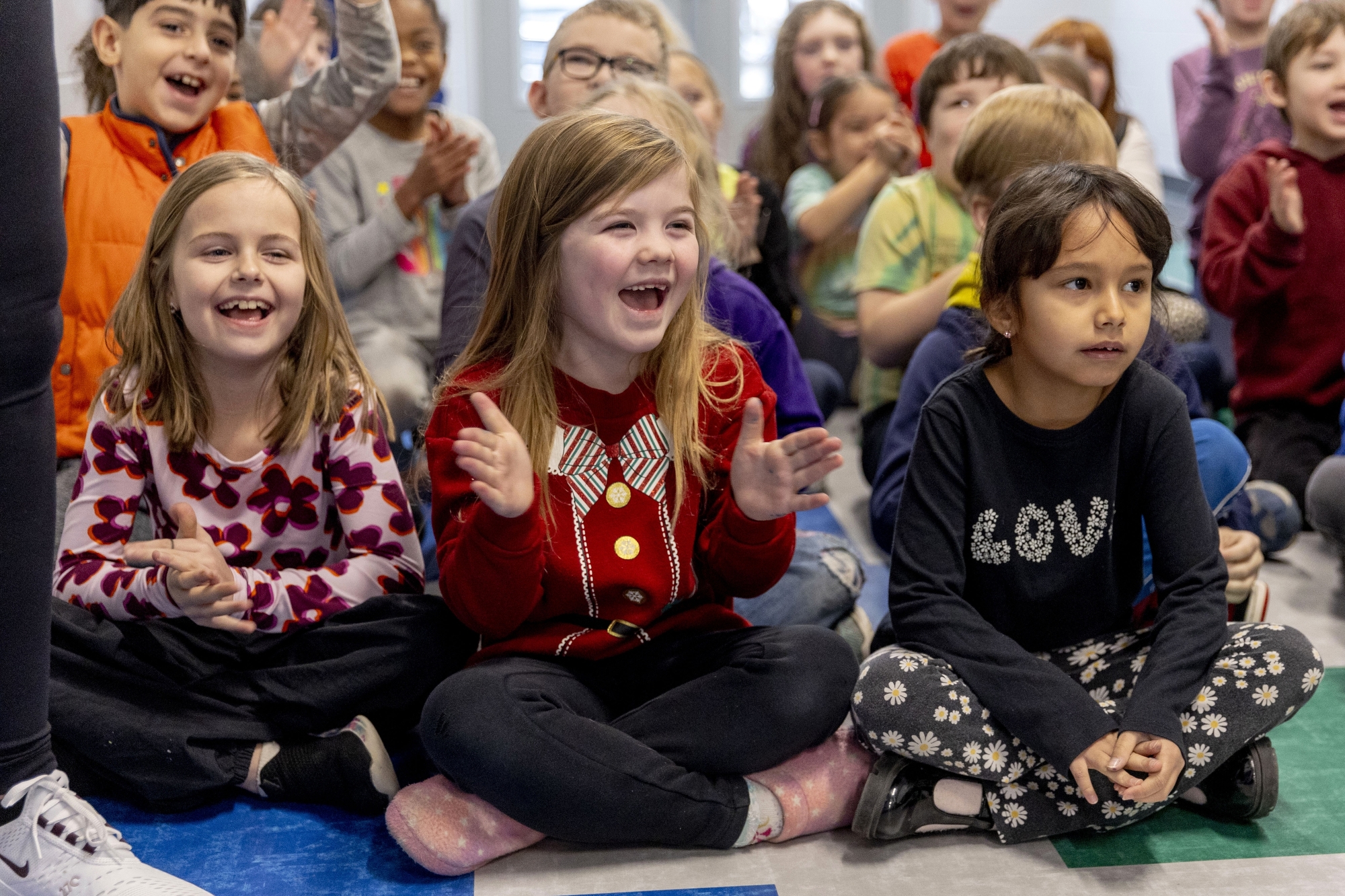 Schickler Elementary second-grader Ada Land smiles and applauds as she celebrates the opening of the new multi-purpose room and gymnasium on Friday, Jan. 10, 2025 in Lapeer. Jake May | MLive.com