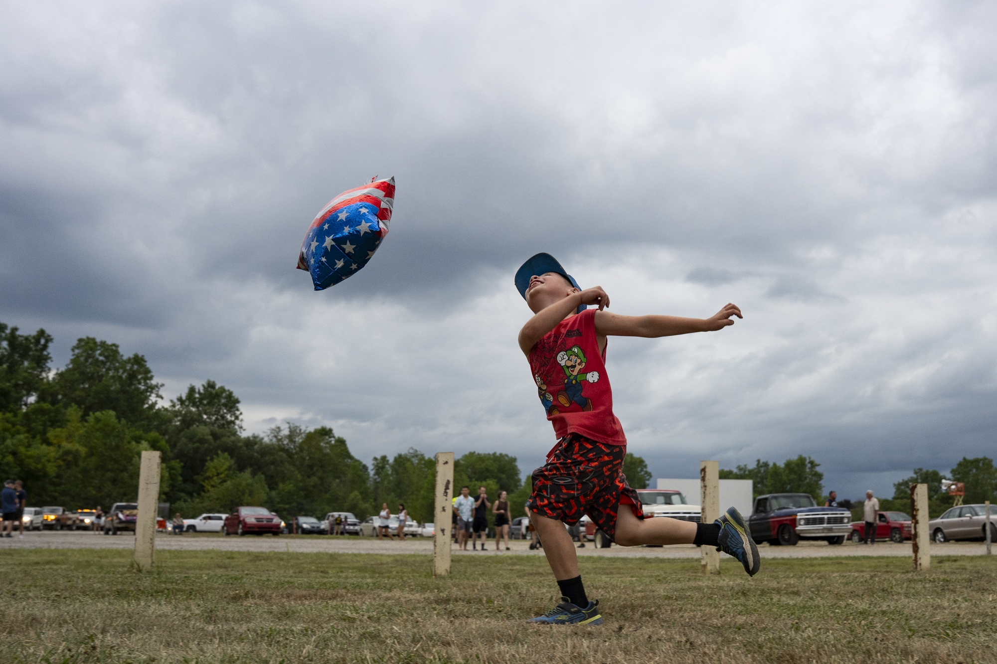 Memphis Rogers, 6, plays with an American flag balloon at Brick Flick at the US 23 Drive in Theater in Flint during the Back to the Bricks main event week on Tuesday, August 12, 2025. 
