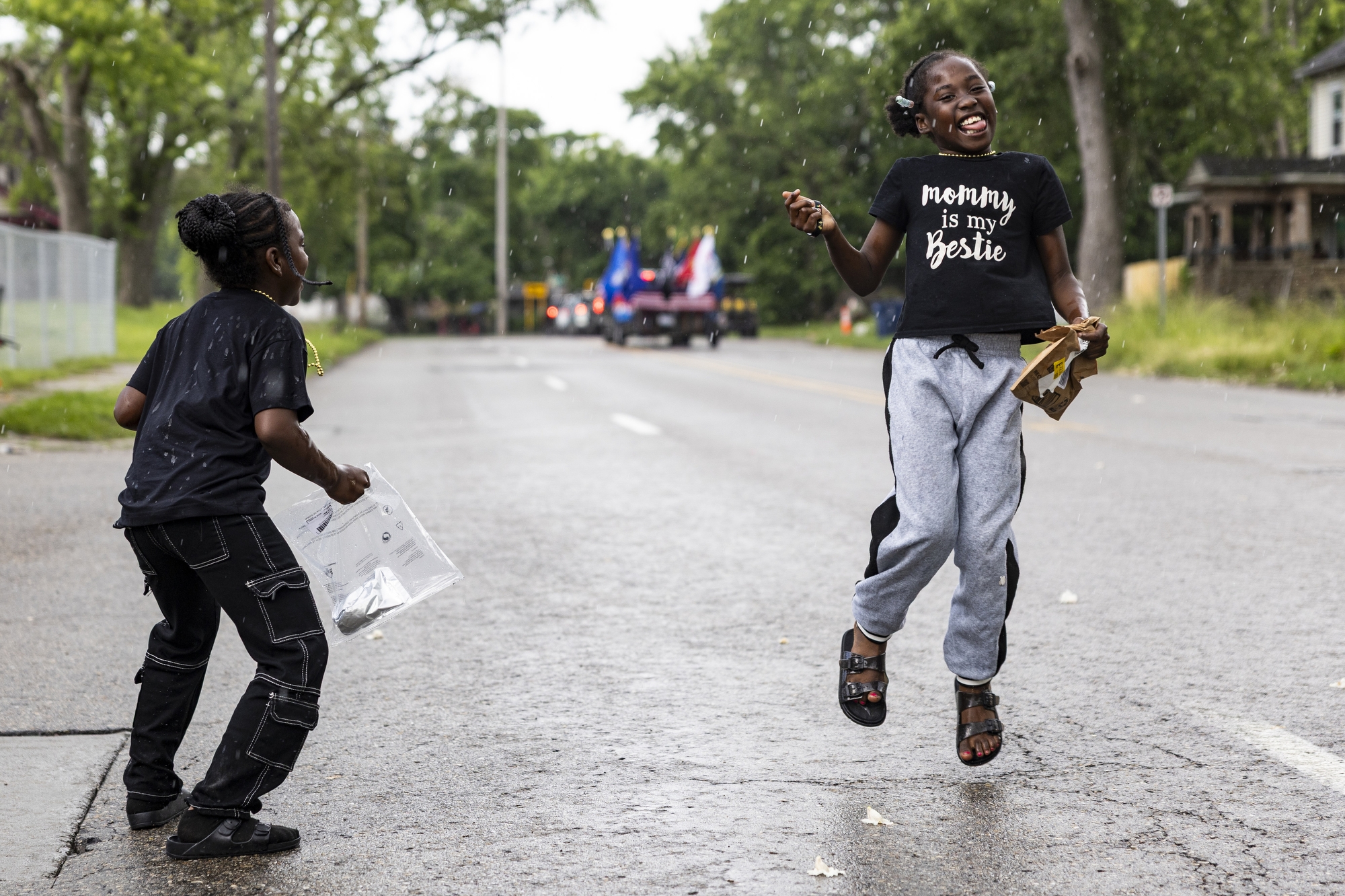 Karneishia Nelson and Lanyaah Henderson, left to right, dance in the rain during a Juneteenth Celebration Parade in Flint on Thursday, June 19, 2025. The parade started at Max Brandon Park and ended around Riverbank Park.