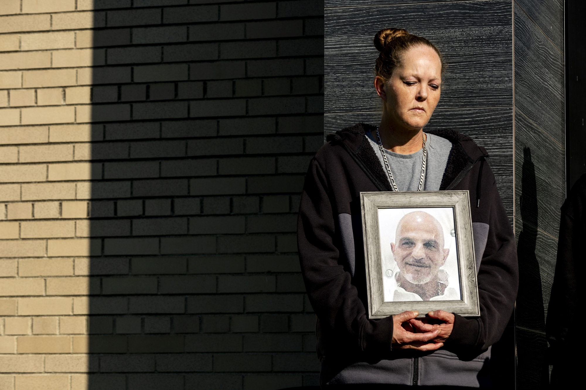 Christina Shamma stands solemnly with a picture frame of her husband Nael Shamma in her hand as the Flint Alliance for Immigrant Rights (FAIR), a coalition of organizations, advocates, and community members committed to protecting the rights and dignity of immigrants in the Greater Flint region, hold a press conference on Tuesday, August 26, 2025 at the Gloria Coles Flint Public Library in response to the Metro Police Authority of Genesee County entering into a 287(g) taskforce agreement with U.S. Immigration and Customs Enforcement (ICE) Enforcement and Removal Operations. (Jake May | MLive.com)