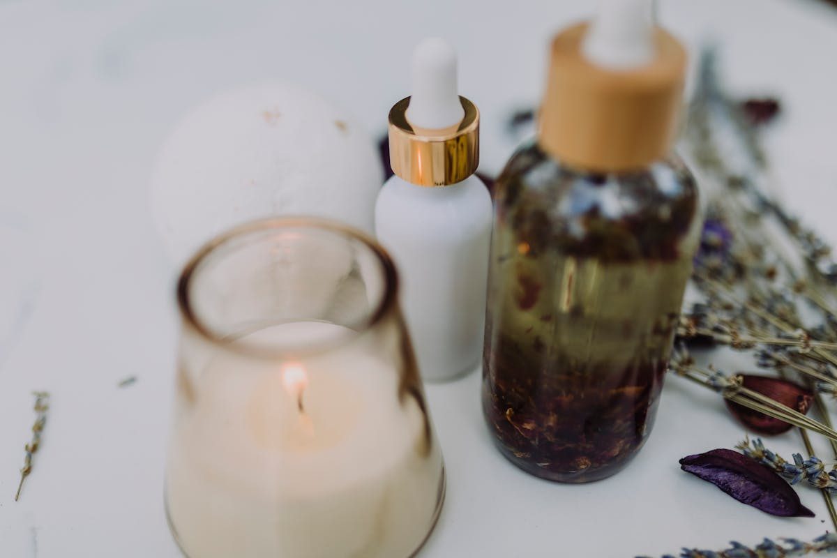 a skincare product bottle next to a candle