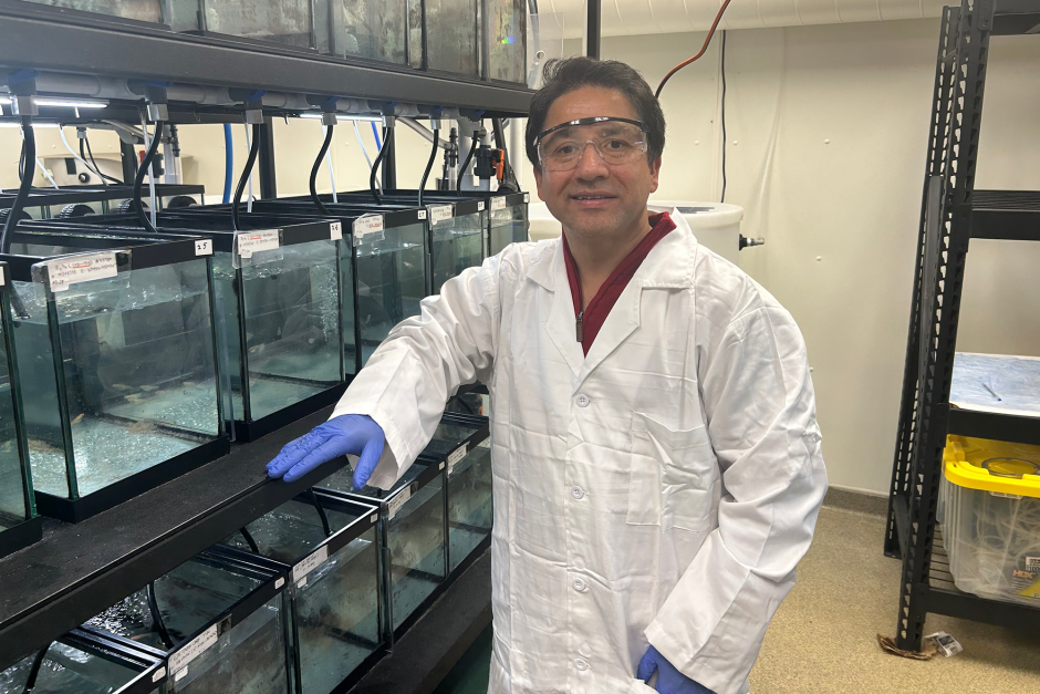 Ramji Bhandari posing in front of fish tanks.