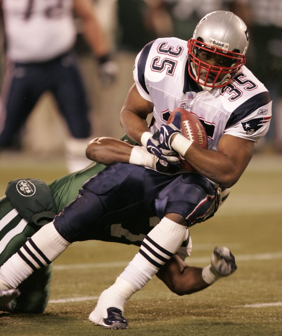 New England Patriots fullback Patrick Pass is brought down by New York Jets linebacker Darrell...