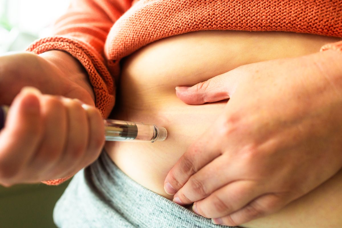 Close up of a woman's hands holding a weight loss injection pen