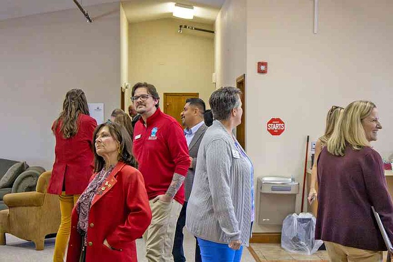 Members of the Greater Hot Springs Chamber of Commerce Ambassadors, known as the Red Coats, tour the Wellness Day area at the Hot Springs Community Resource Center Monday afternoon. (The Sentinel-Record/Thomas Buckman)