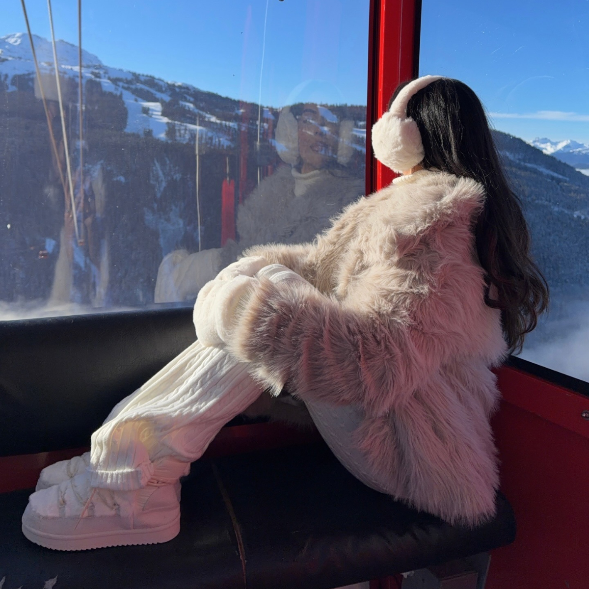 A woman sitting in a ski lift during winter.