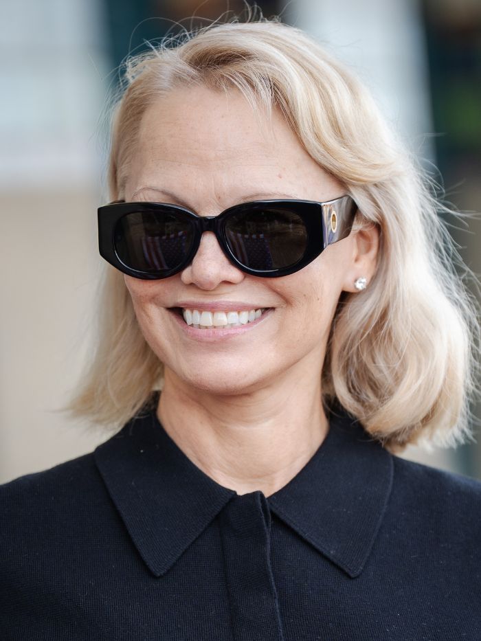Pamela Anderson on September 06, 2025 in Deauville, France wearing a black top and sunglasses with thin eyebrows and a blonde bob hairstyle