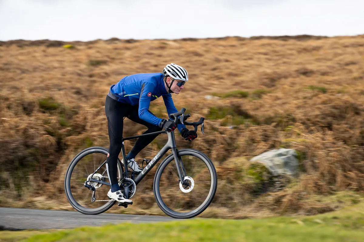 Male cyclist in blue top riding the Cube Attain C:62 SLT road bike