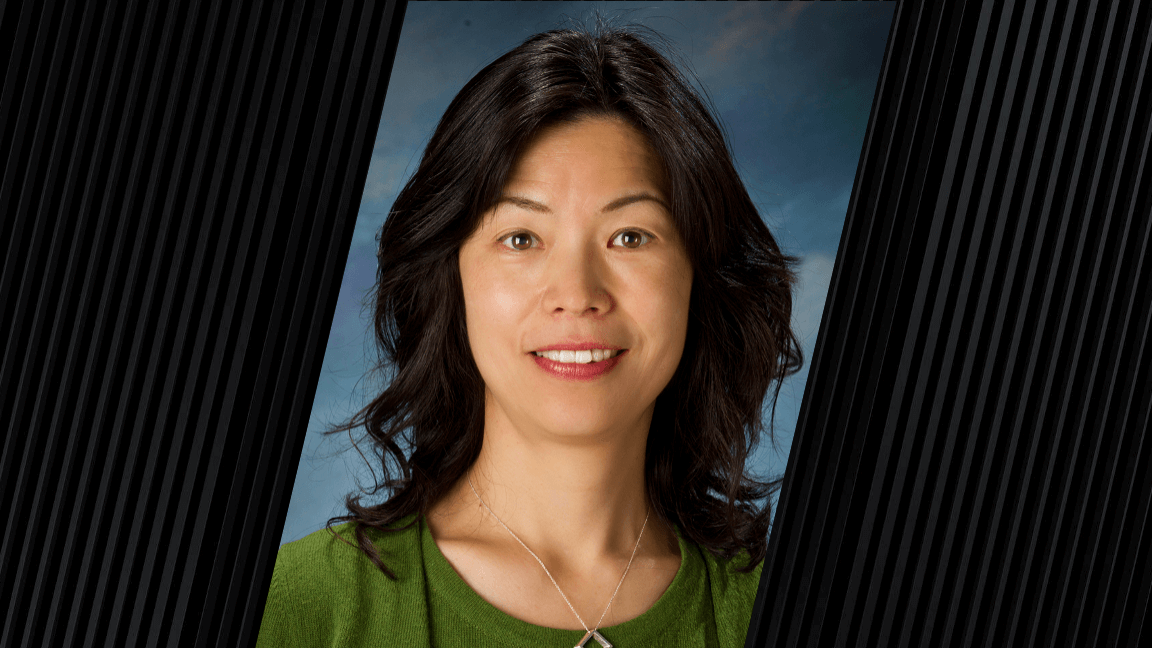 portrait of woman with long dark hair and wearing a green shirt and silver necklace