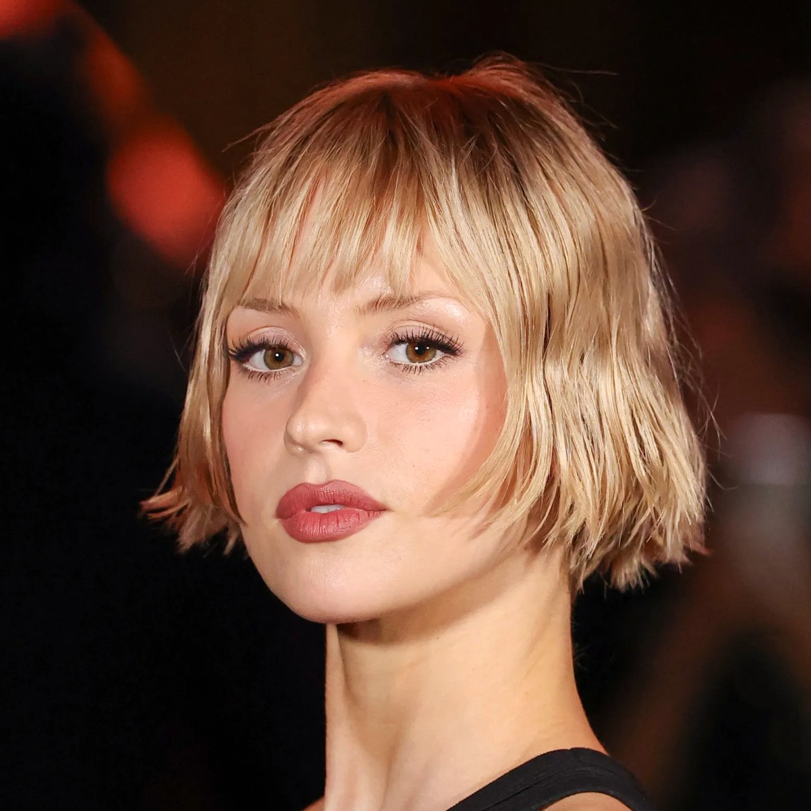 A model with her blonde hair styled in a tousled euro bob with micro bangs.