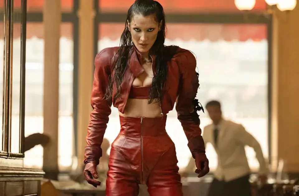 Bella Hadid in a tense moment from FX’s “The Beauty,” wearing a red leather look tied to her character’s storyline.