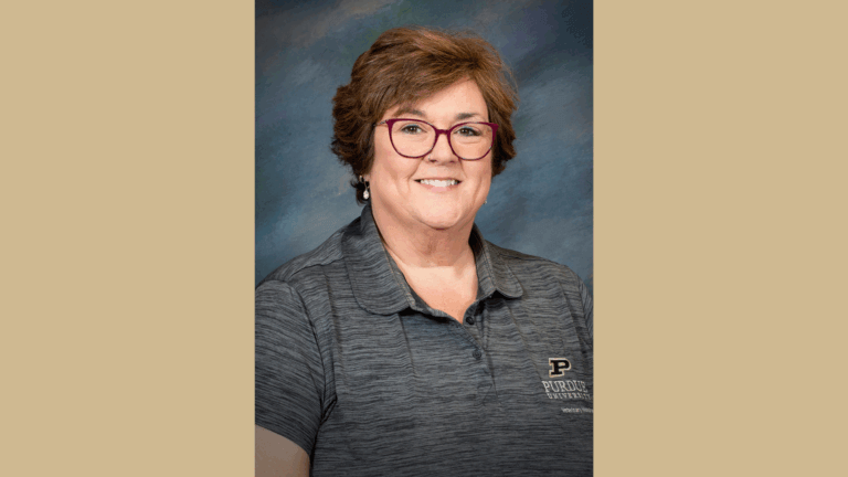 portrait of a woman with shoulder length brown hair, wearing glasses and a gray shirt