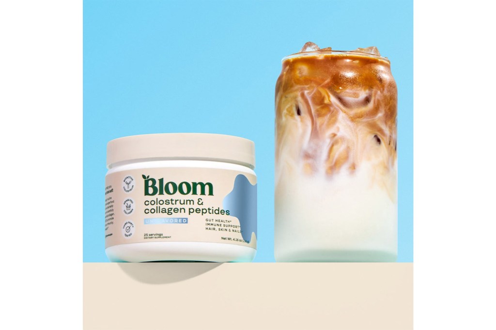 Bloom colostrum and collagen peptides supplement container next to a glass of iced coffee.