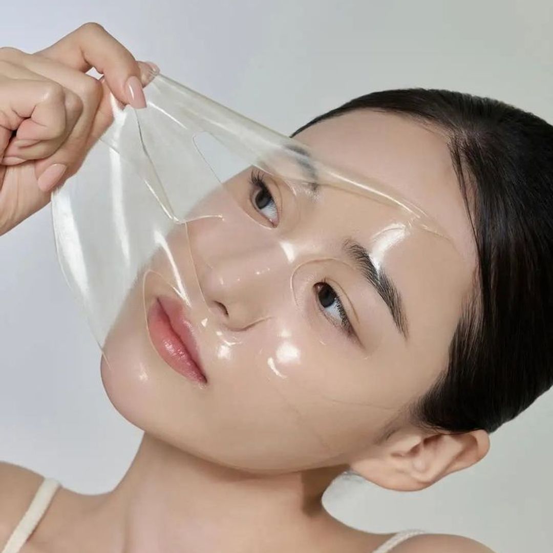 a woman removing a fcae mask 