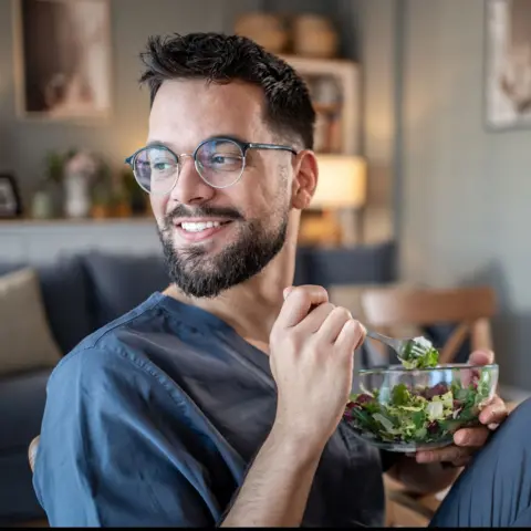 Getty Images A young man eating a healthy salad
