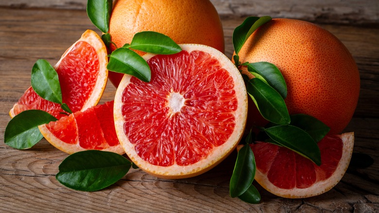 halved, sliced, and whole grapefruit on wood