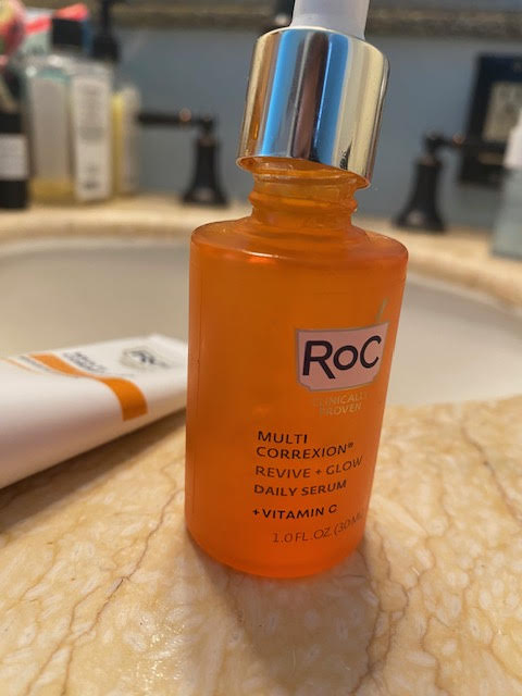 An orange bottle of RoC Multi Correxion Revive + Glow Daily Serum + Vitamin C.
