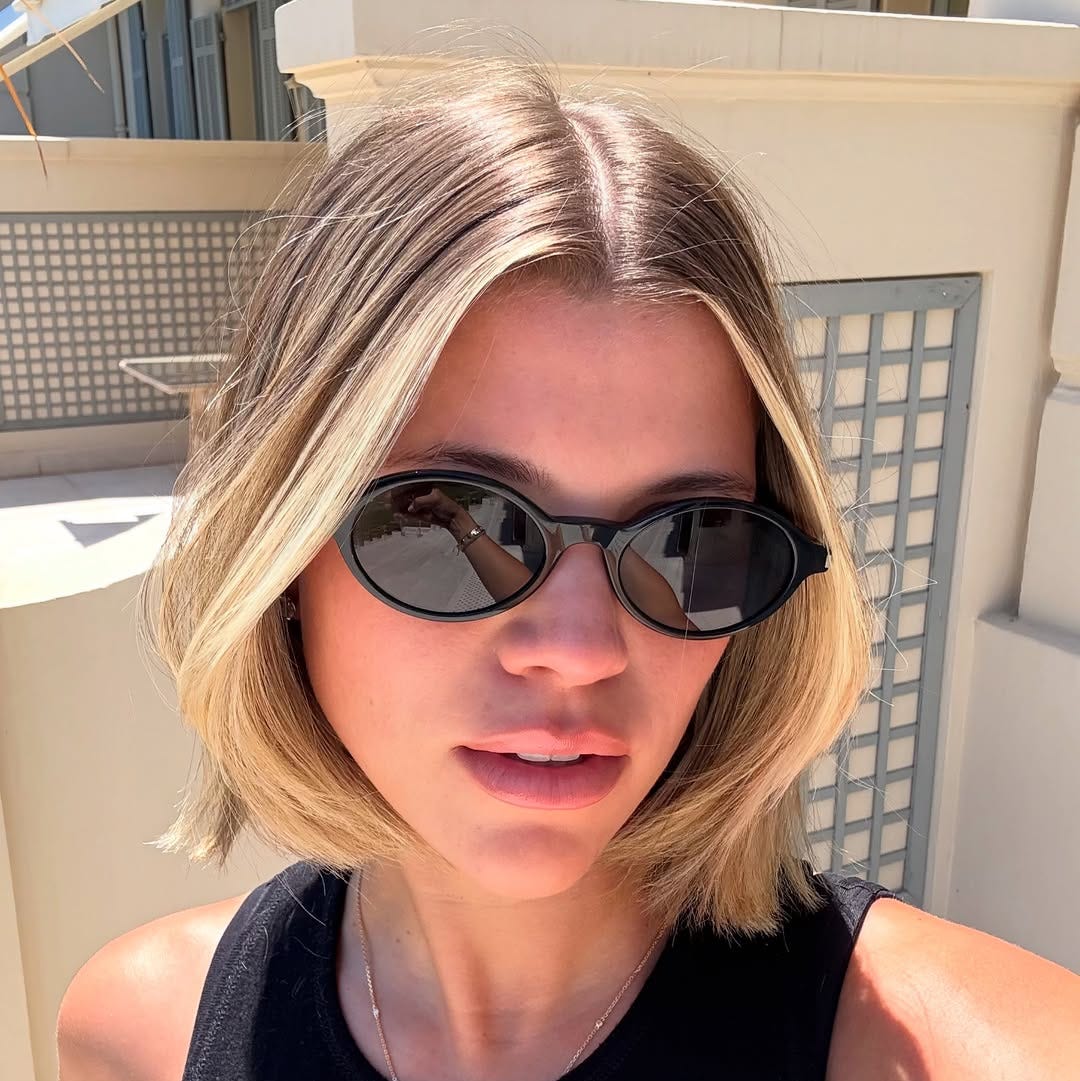 portrait of a person with sunglasses in a sunny outdoor setting