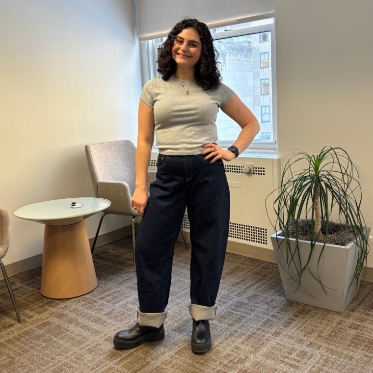 A woman wearing Spanx’s SpanxShape Authentic 360 Cuffed Horseshoe Jeans and a grey T-shirt.