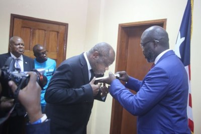 Former Minister of Finance Samuel Tweah being commissioned by former president Weah (file photo)