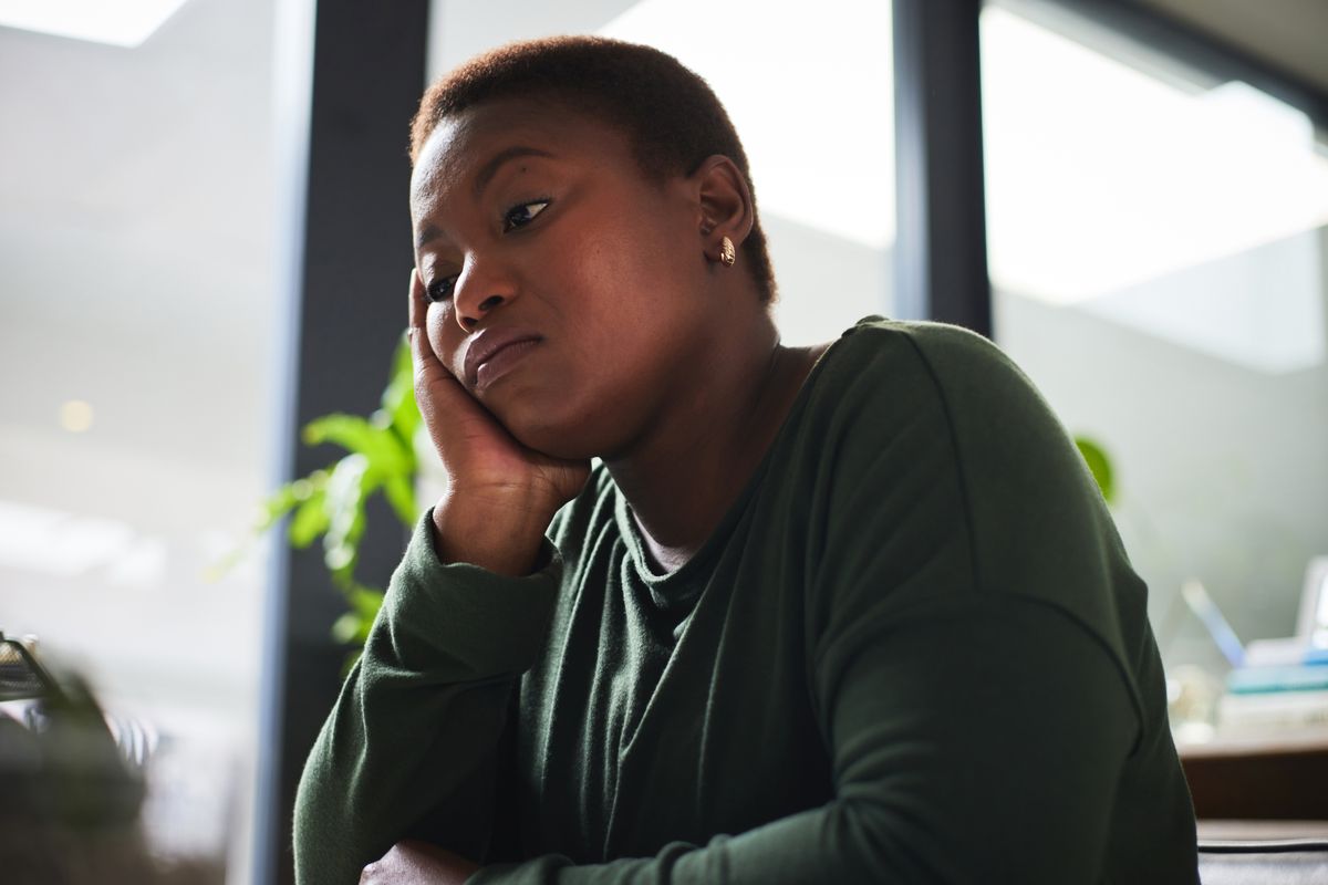 Woman looks tired as she sits at desk in office