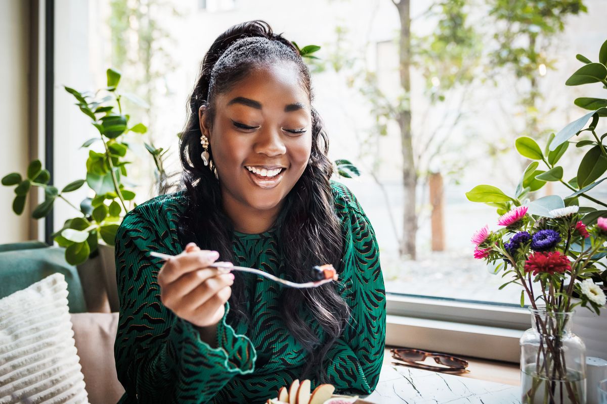 Young woman eating and smiling