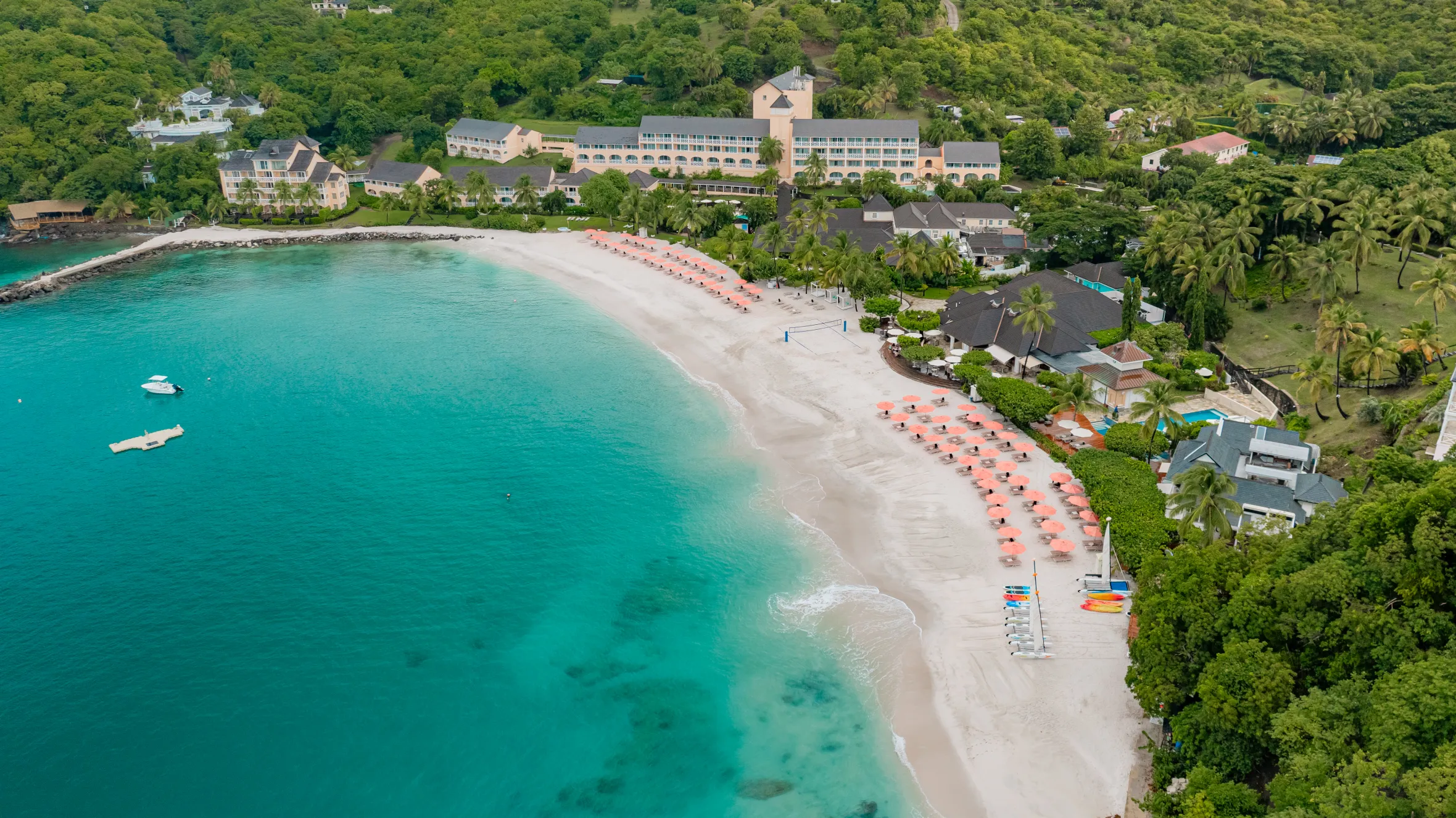 Aerial view of The BodyHoliday hotel with its beach and surrounding lush green landscape.