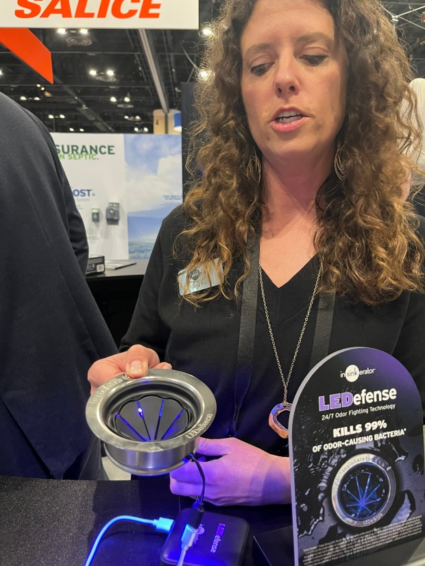 Carly Kelly demonstrates InSinkErator's new LEDefense system at the International Builders' Show in Orlando. The system uses LED lights to kill odor-causing bacteria in garbage disposals. (GrowthSpotter staff)