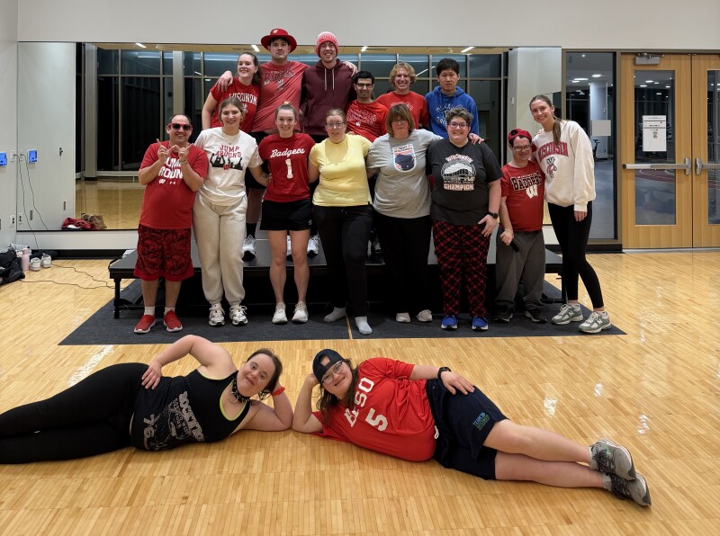 A large group photo showing athletes posing for a photo at the end of a fitness class.