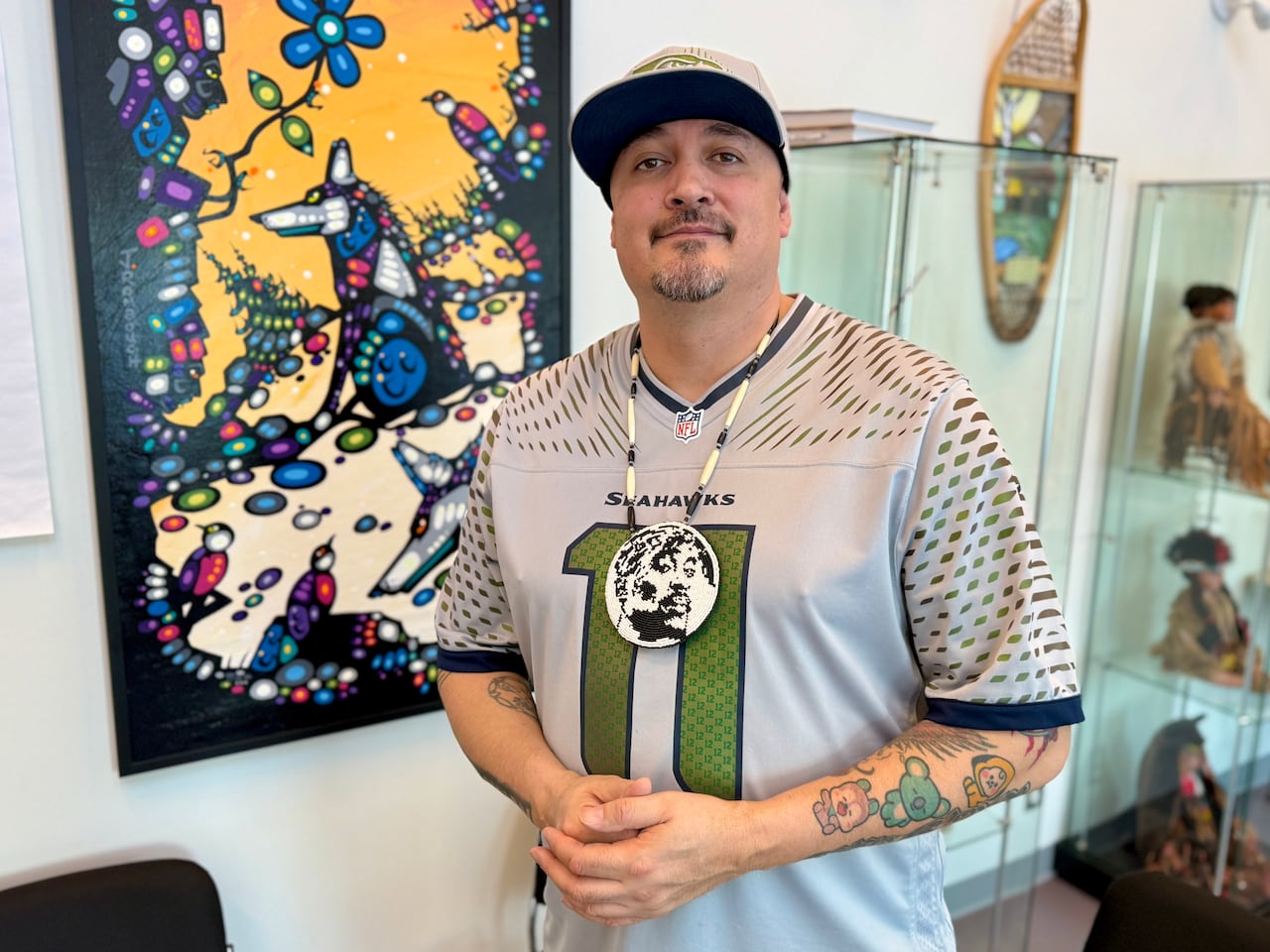 A man stands slightly smiling to the camera