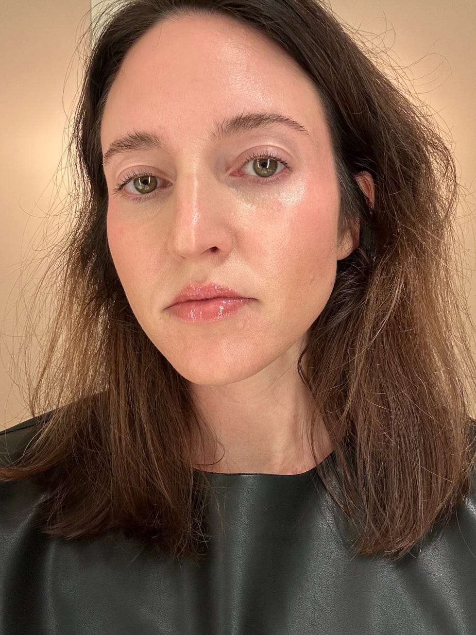 A person with long, dark, slightly messy hair wearing a black outfit.