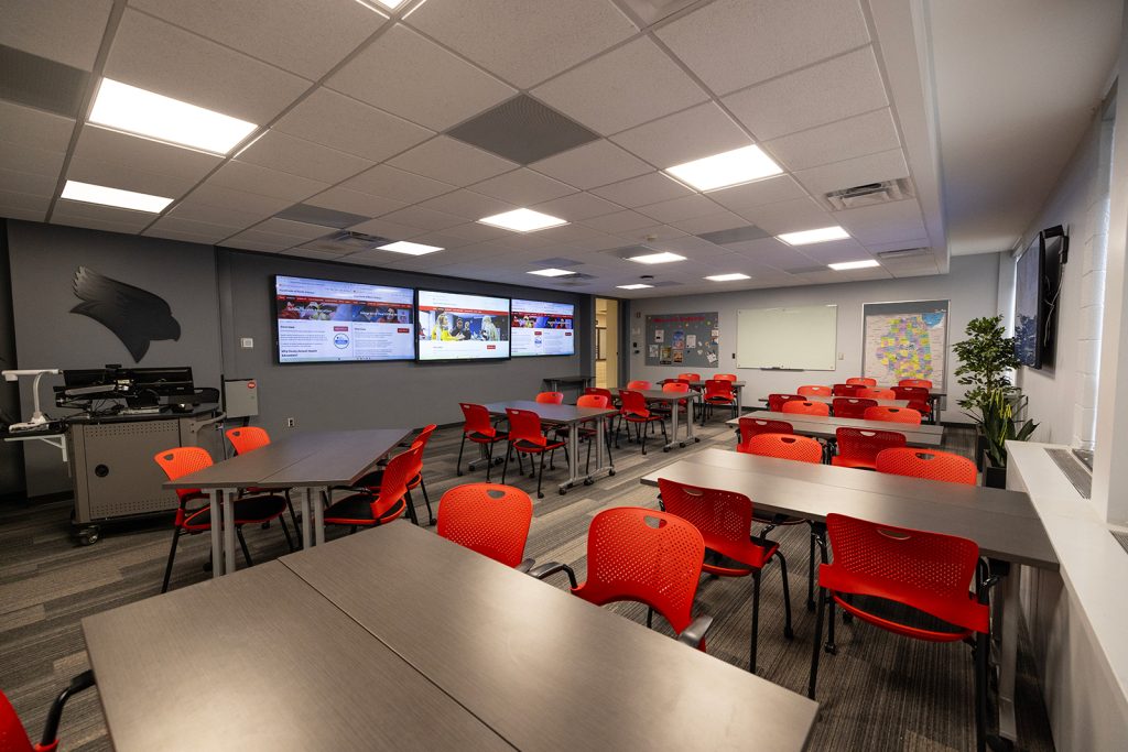 Lab with desks, chairs, and large screens.