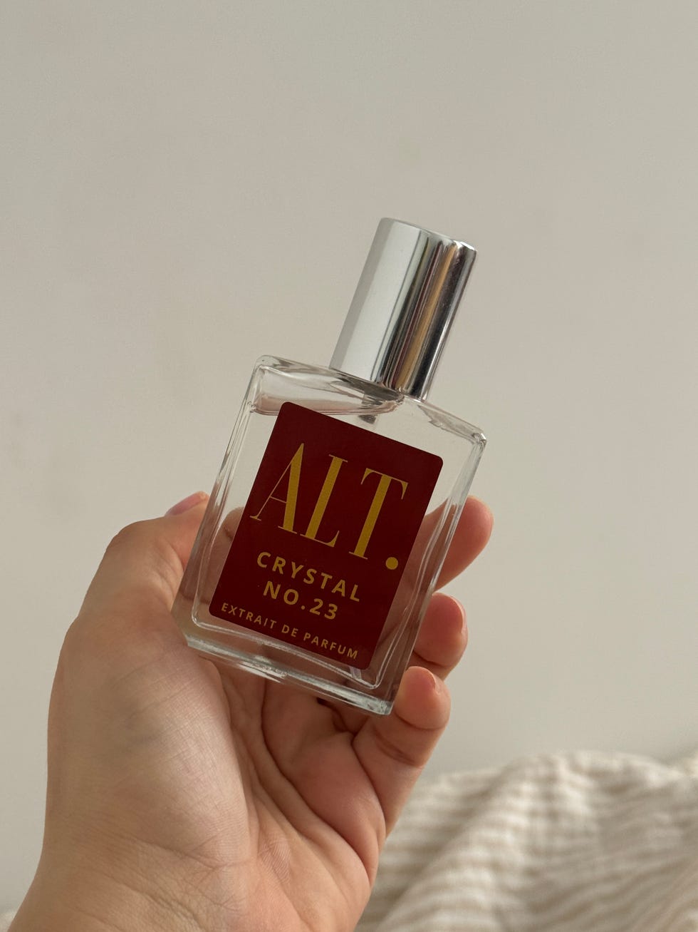 Fragrance bottle held in hand.
