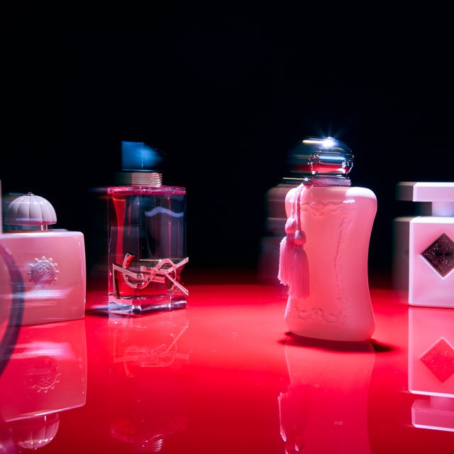 Collection of various perfume bottles arranged on a reflective surface.
