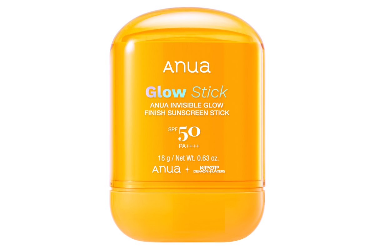 Anua Glow Stick sunscreen in a bright orange container, SPF 50 PA++++, 18g, product info printed on front, isolated on a white background.