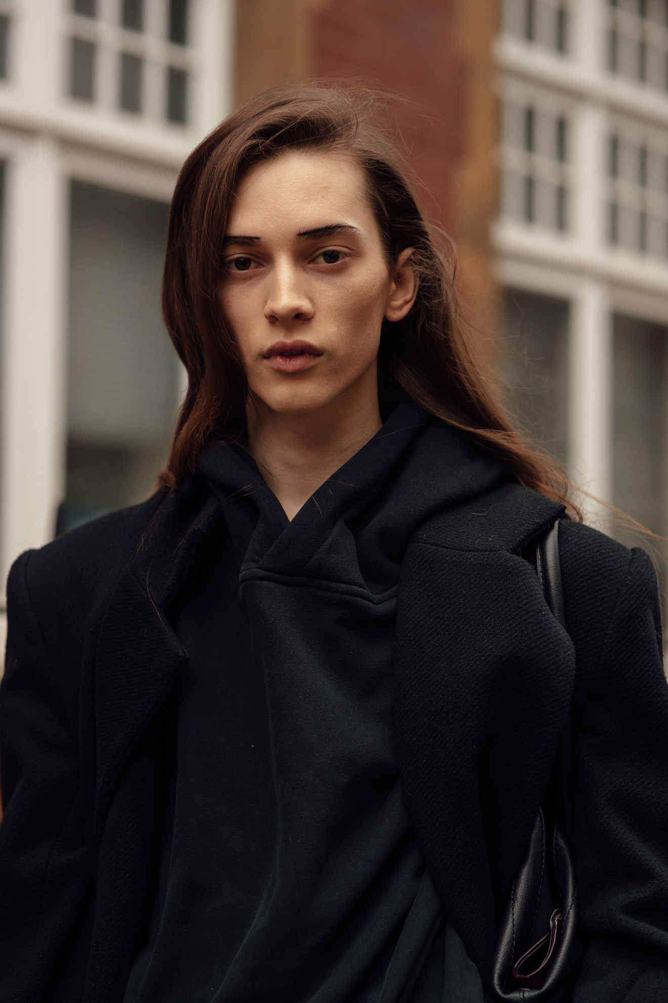 A woman with long side-parted hair, berry stained lips and brows accentuated with a black eyeliner