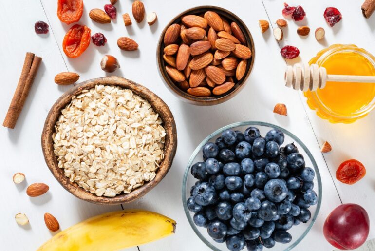 Oatmeal, blueberries, almonds and honey for cooking breakfast porridge. Top view of healthy ingredients for breakfast