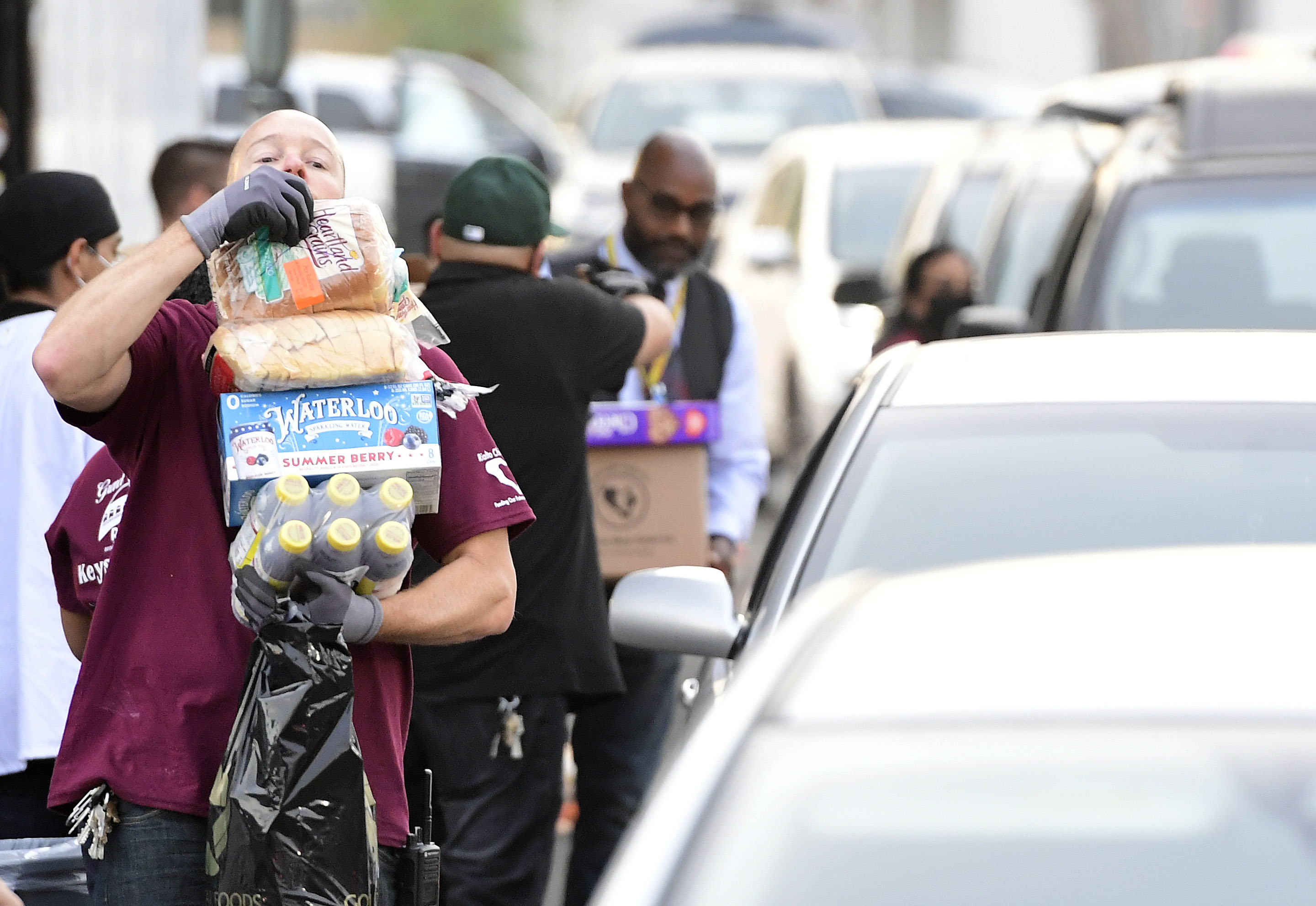 Rialto Unified School District employee Mike Devlin balances food as...